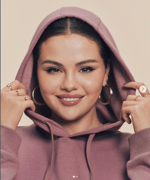 Selena modeling a sweatsuit from her brand Rarebeauty